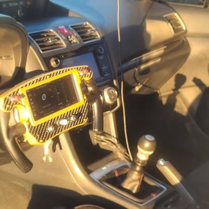The carbon fibre racing steering wheel installed in a car interior