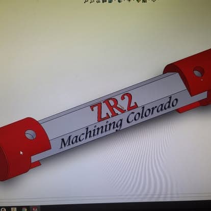 A machined ZR2 badge plate engraved with the Machining Colorado name