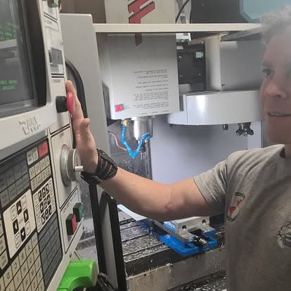 A machinist operating a CNC milling machine in the shop